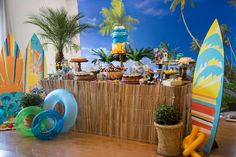 a table with surfboards and cakes on it