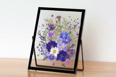 an easel with flowers painted on it sitting on a table