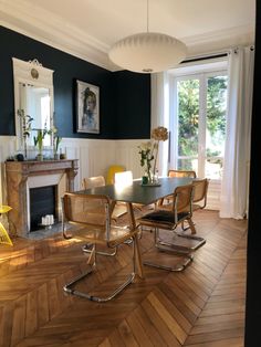 a dining room with wooden floors and black walls