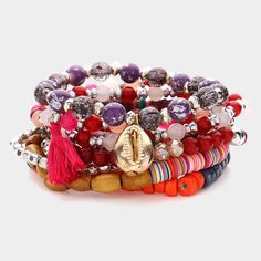 the multicolored bracelets are stacked together with charms and tassels on them