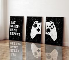 three black and white video game prints on wood flooring next to wall with window