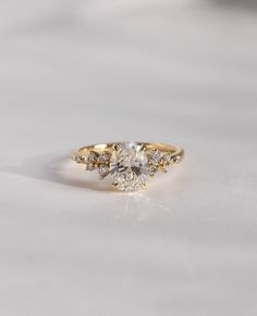 a yellow gold engagement ring with three stones on the front and center stone in the middle