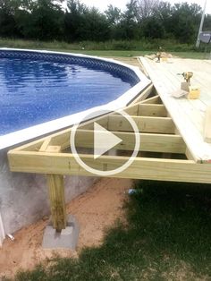 an above ground swimming pool being built with wooden decking and blue water in the background