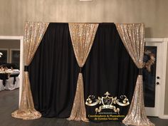 a black and gold decorated room with white table cloths on the floor, two drapes open to reveal curtains