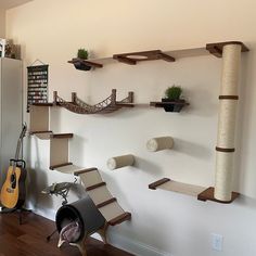 a room with several cat scratching boards on the wall and a guitar in the corner