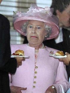 an older woman in a pink hat holding two plates with food on them