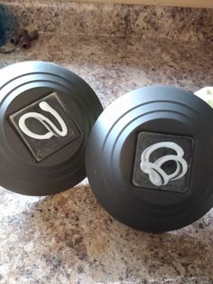 two black dumbbells sitting on top of a counter