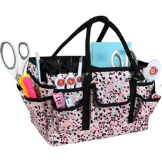 a pink and black polka dot purse with scissors, pencils, pens and other items in it