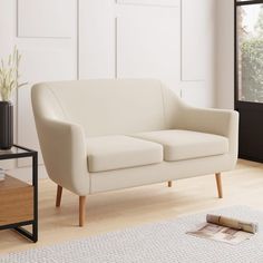 a white couch sitting on top of a hard wood floor