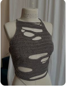 a crocheted top is displayed on a mannequin