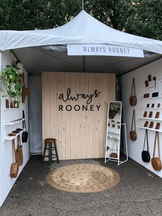 an outdoor room that has various items on the wall and in front of it, there is a sign reading always roony