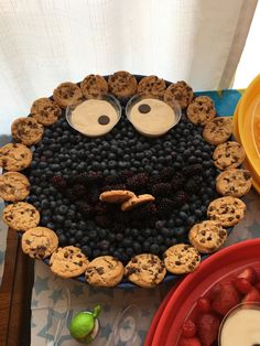 a cake made to look like a cookie monster with eyes and nose surrounded by berries