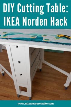 A white IKEA Norden gate-leg dining table with elevated legs and castors, opened fully with fabric and sewing pattern laid out on top and a rotary cutter Ikea Norden Table, Norden Table, Ikea Norden, Office Craft Room Combo, Craft Room Tables, Ikea Craft Room, Sewing Room Furniture, Ikea Crafts, Sewing Room Inspiration