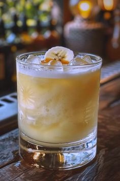 a glass filled with a drink sitting on top of a wooden table