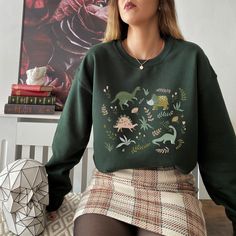 This fun dinosaur print sweatshirt features boho-style drawings of all your favorite dinos. This trendy design will your new favorite sweatshirt that you reach for again and again. Makes a great gift for any dinosaur lover or paleontology enthusiast. * Q U I C K * F A C T S * ♥ 50% cotton / 50% poly fabric blend ♥ Design is high quality digital print ♥ Washed on cold and air dried is best, but regular/washing and drying is fine as well! * S I Z I N G * ♥ Sizing is unisex so runs like men's, thou Casual Printed Sweatshirt For Fall, Dinosaur Outfit Aesthetic, Dinosaur Outfit Women, Dinosaur Inspired Outfit, Casual Printed Crew Neck Sweatshirt, Printed Crew Neck Casual Sweatshirt, Casual Printed Relaxed Fit Sweatshirt, Casual Dinosaur Print Tops For Fall, Cotton Tops With Dinosaur Print For Fall