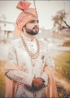 a man wearing a turban and standing in the grass