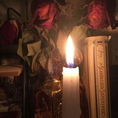 a candle is lit in front of some books