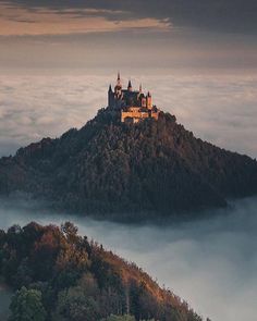 a castle on top of a hill surrounded by fog