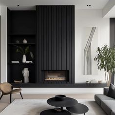 a modern living room with black and white decor on the walls, fireplace and shelves