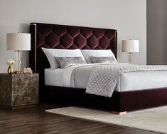 a bedroom with a bed, nightstands and two lamps on either side of the bed