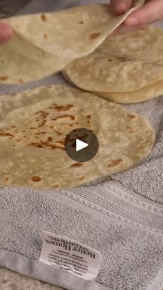 two tortillas are being prepared on a towel