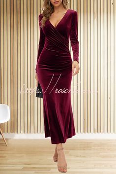 a woman in a burgundy dress standing on a wooden floor