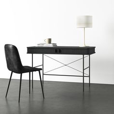 a black desk with a lamp and chair next to it