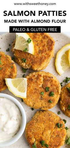 salmon patties on a plate with lemon wedges and mayonnaise for dipping