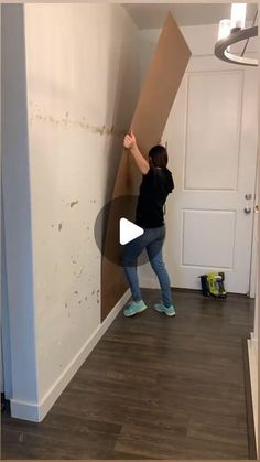 a woman standing in front of a wall with a cardboard box on it