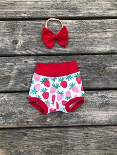 Strawberry themed bummie shorts. Made with soft cotton spandex knit with red and pink strawberries. Red waist and cuffs. Matching red bow on nylon headband. Bummies are made to be a little smaller than regular shorts and fit snug. If you don't want them snug order a size up. Matching white bodysuit with ONE in red. Cute Fitted Red Bottoms, Cute Red Stretch Bottoms, Cute Red Bottoms For Playtime, Playful Bottoms For First Birthday In Summer, Cute Summer Bottoms For Birthday, Cute Stretch Red Bottoms, Fun Red Summer Bottoms, Playful Summer Bottoms For First Birthday, Cute Short Red Bottoms