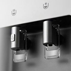 two cups are attached to the front of an appliance