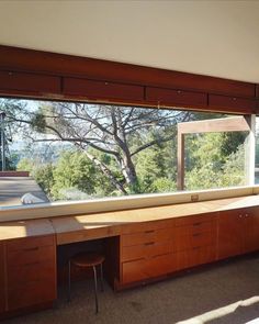 a room with a large window and desk in front of the window is an outside view