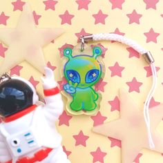 a keychain with an alien on it next to a star