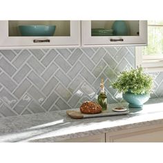 a kitchen counter with some bread and flowers on it, in front of two white cupboards