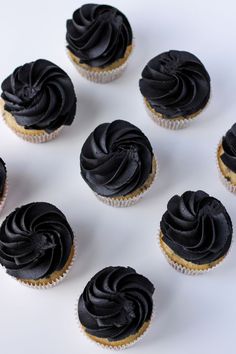 there are many cupcakes with black frosting on them