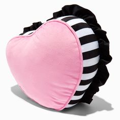 a pink heart shaped pillow sitting on top of a black and white striped pillow cover