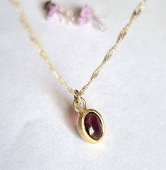 "Beautiful solid gold pendant necklace with an oval red garnet, minimalist jewelry for women in 9k or 14k solid yellow gold. This regal necklace is solid gold and has an oval solid gold pendant. The pendant is set with an oval garnet with a deep red color. It is available in 9k or 14k solid yellow gold in 16\" or 18\" lengths. This necklace is simply breathtaking. It is delicate and romantic yet striking and meaningful. You can wear it as a single item or layered with other necklaces for a total boho-chic look. It will accompany you for many years to come. Don't hesitate to order this fabulous necklace and enrich your look with this romantic piece. Item details: 1 solid gold pendant necklace. Dimensions: Pendant size: 0.4\"x0.3\" (9.5mmX7.5mm). Gemstone size: 0.23\"x0.31\" (6mmX8mm). Neckl Yellow Gold Garnet Necklaces With Oval Shape, Yellow Gold Oval Garnet Necklace, Gold Oval Garnet Necklaces, Oval Garnet Gold Necklace, Elegant 14k Gold Birthstone Necklace With Oval Pendant, 14k Gold Gemstone Oval Pendant Necklace, Oval Pendant Birthstone Necklace In 14k Gold, 14k Gold Birthstone Oval Pendant Necklace, 14k Gold Oval Pendant Birthstone Necklace Gift