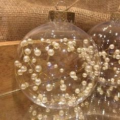 two glass ornaments sitting on top of a wooden table