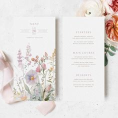 the wedding stationery is laid out next to flowers