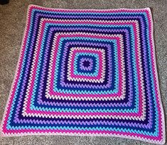 a crocheted blanket is laying on the floor