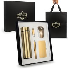 a black and gold gift box containing a lighter, notebook, pen, phone case, keychain and other items