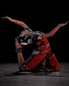 a woman in red and black dancing on the floor