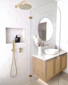 a bathroom with a sink, mirror and shower head on the wall next to it