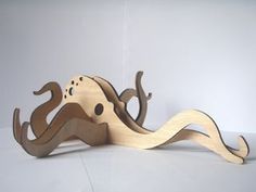 a wooden toy with an octopus on it's back and its tail curled up