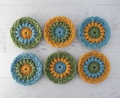 six crocheted coasters with different colors and designs on top of a white table