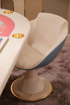 a white chair sitting on top of a wooden floor next to a table with a pen and pencil