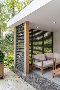 an outdoor living area with two chairs and a coffee table