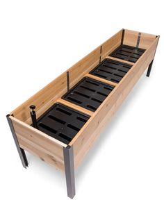 a wooden bed frame with metal legs and black trays on the bottom, against a white background