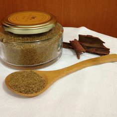 a wooden spoon sitting next to a jar filled with spices