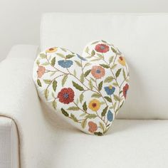 a heart shaped pillow sitting on top of a white couch